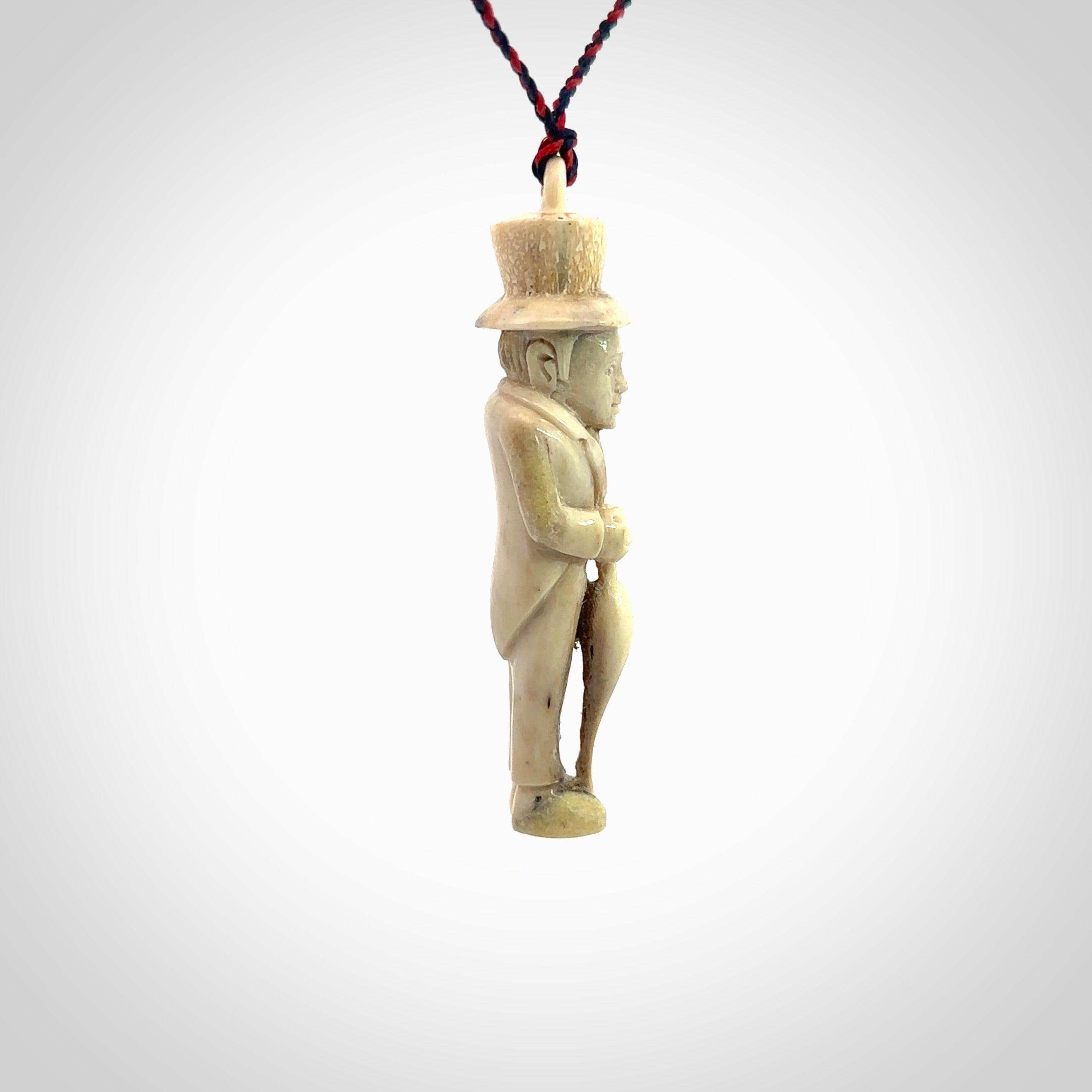 This unique contemporary hunchback with red pepper piece is hand carved in deer antler, bone and is a one off pendant. It is a delightful, large sized and artistic piece of jewellery. One only necklace. We provide this pendant on a blue and red adjustable cord.