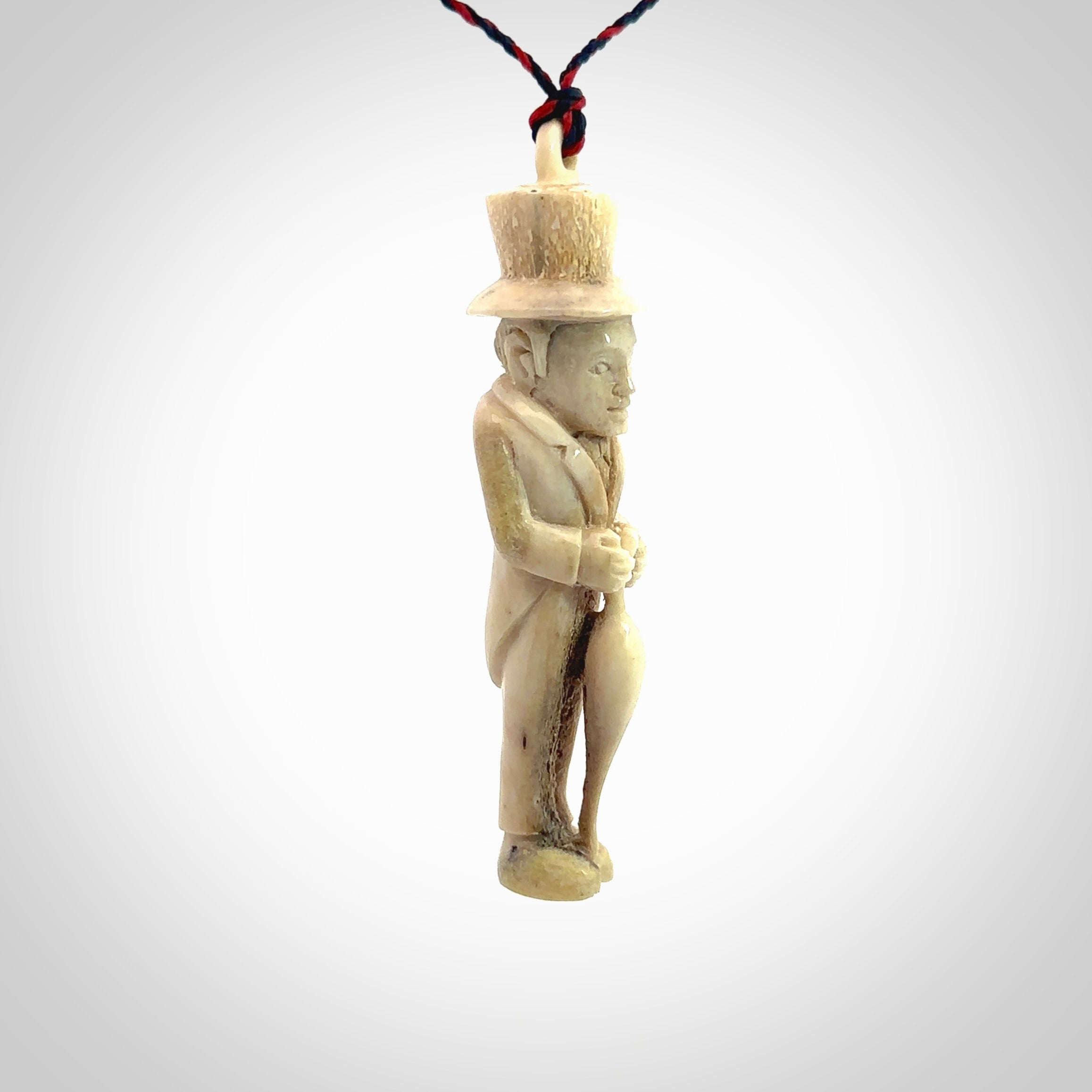 This unique contemporary hunchback with red pepper piece is hand carved in deer antler, bone and is a one off pendant. It is a delightful, large sized and artistic piece of jewellery. One only necklace. We provide this pendant on a blue and red adjustable cord.