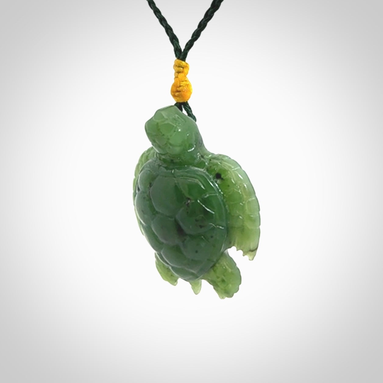 British Columbian jade turtle pendant. Hand carved jade turtle pendant, made by NZ Pacific for sale online. Unique handmade jewellery. Provided with an adjustable cord and packaged in a woven kete pouch.