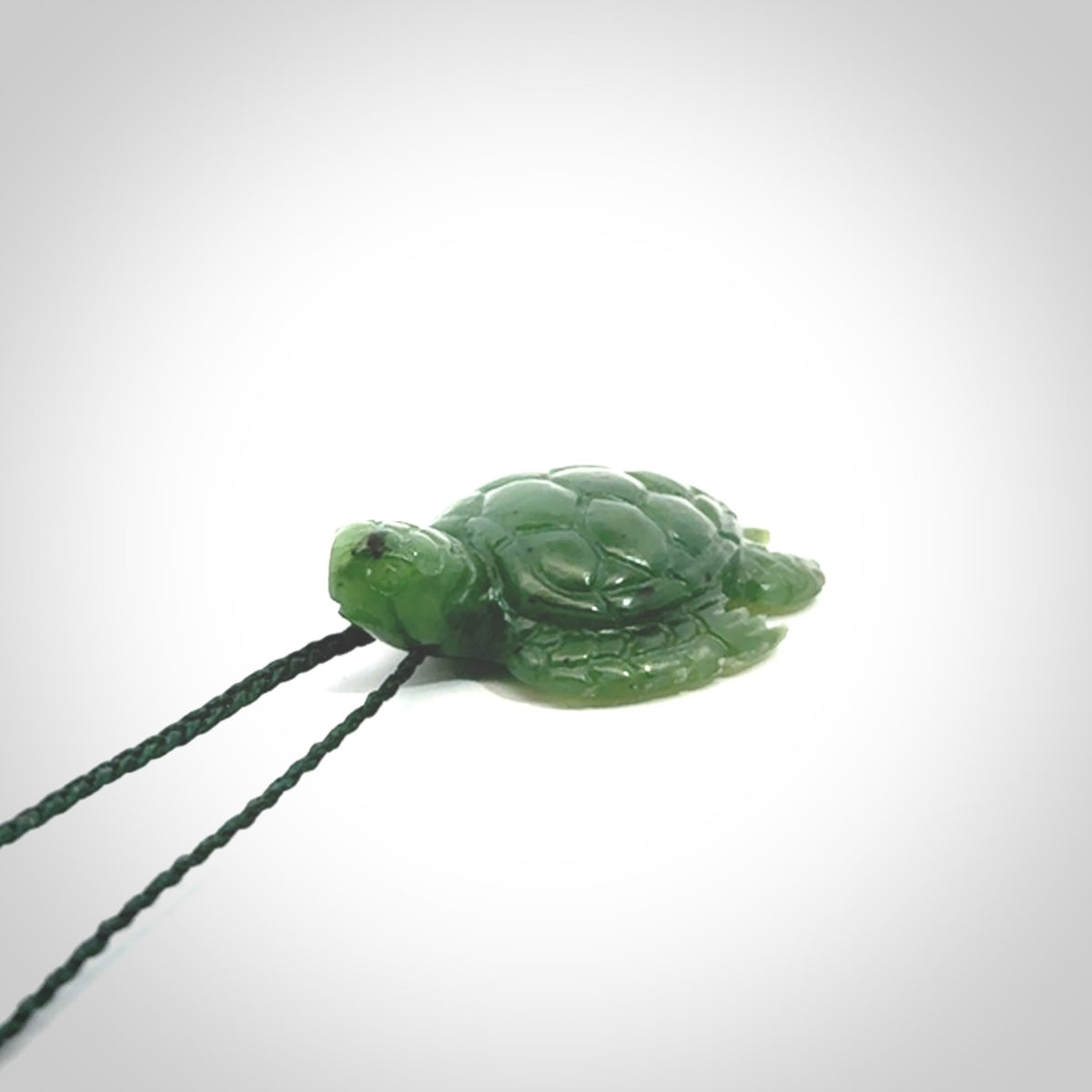 British Columbian jade turtle pendant. Hand carved jade turtle pendant, made by NZ Pacific for sale online. Unique handmade jewellery. Provided with an adjustable cord and packaged in a woven kete pouch.