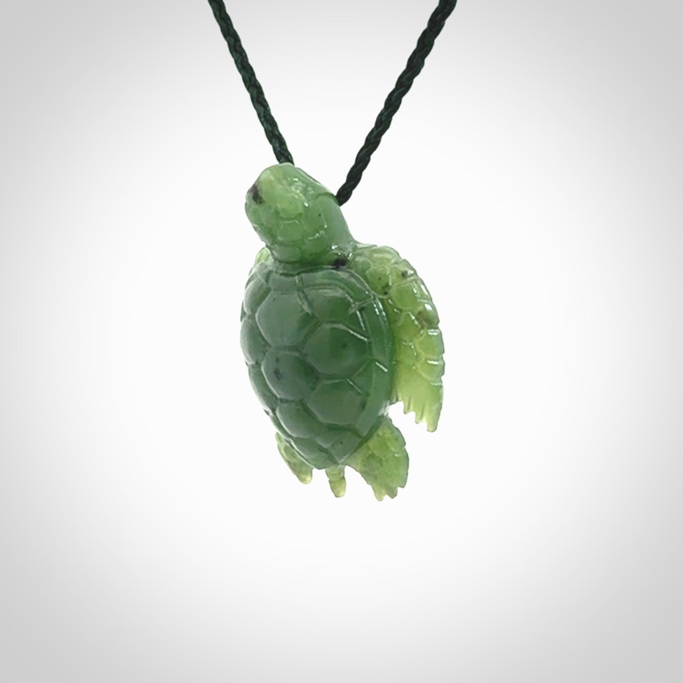 British Columbian jade turtle pendant. Hand carved jade turtle pendant, made by NZ Pacific for sale online. Unique handmade jewellery. Provided with an adjustable cord and packaged in a woven kete pouch.