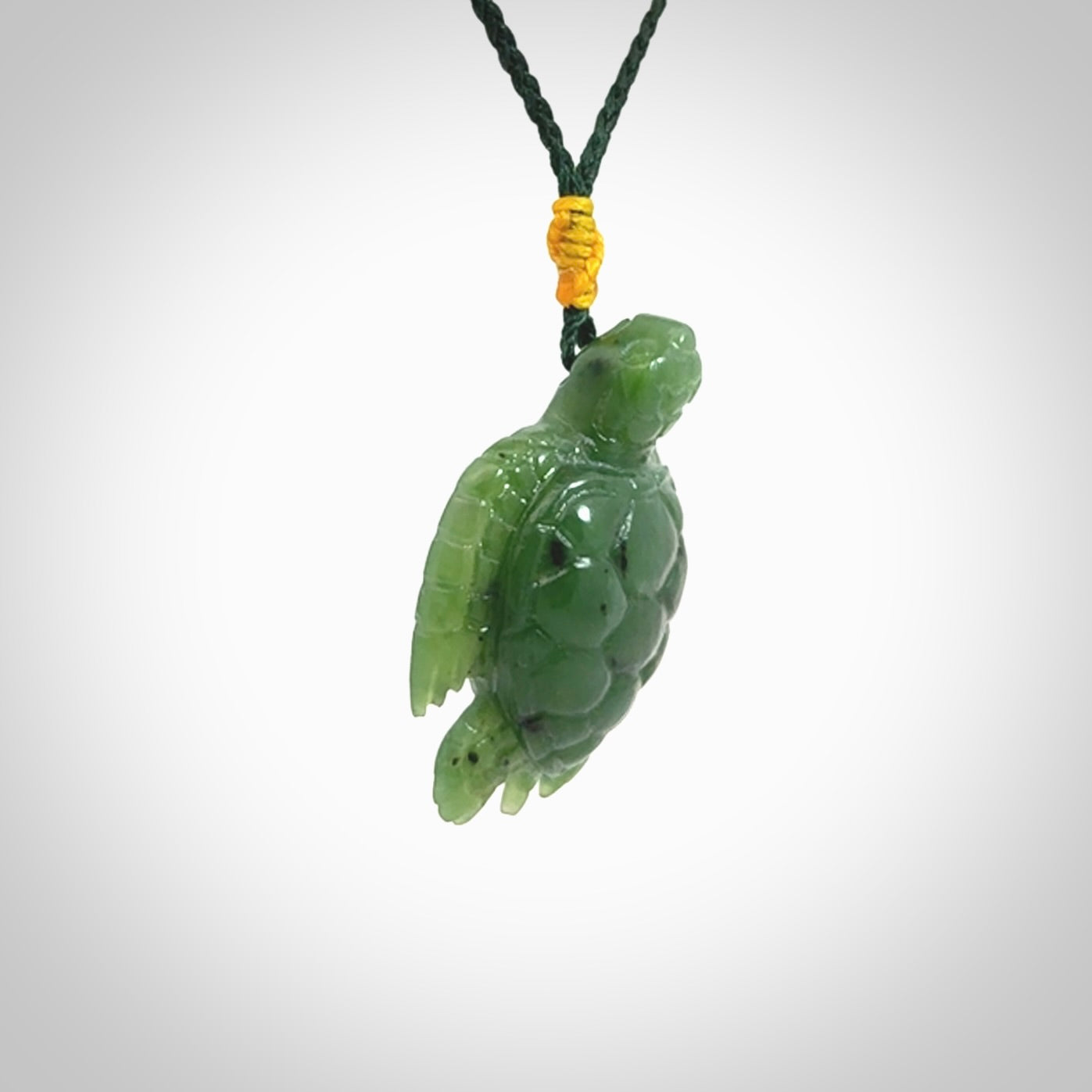 British Columbian jade turtle pendant. Hand carved jade turtle pendant, made by NZ Pacific for sale online. Unique handmade jewellery. Provided with an adjustable cord and packaged in a woven kete pouch.