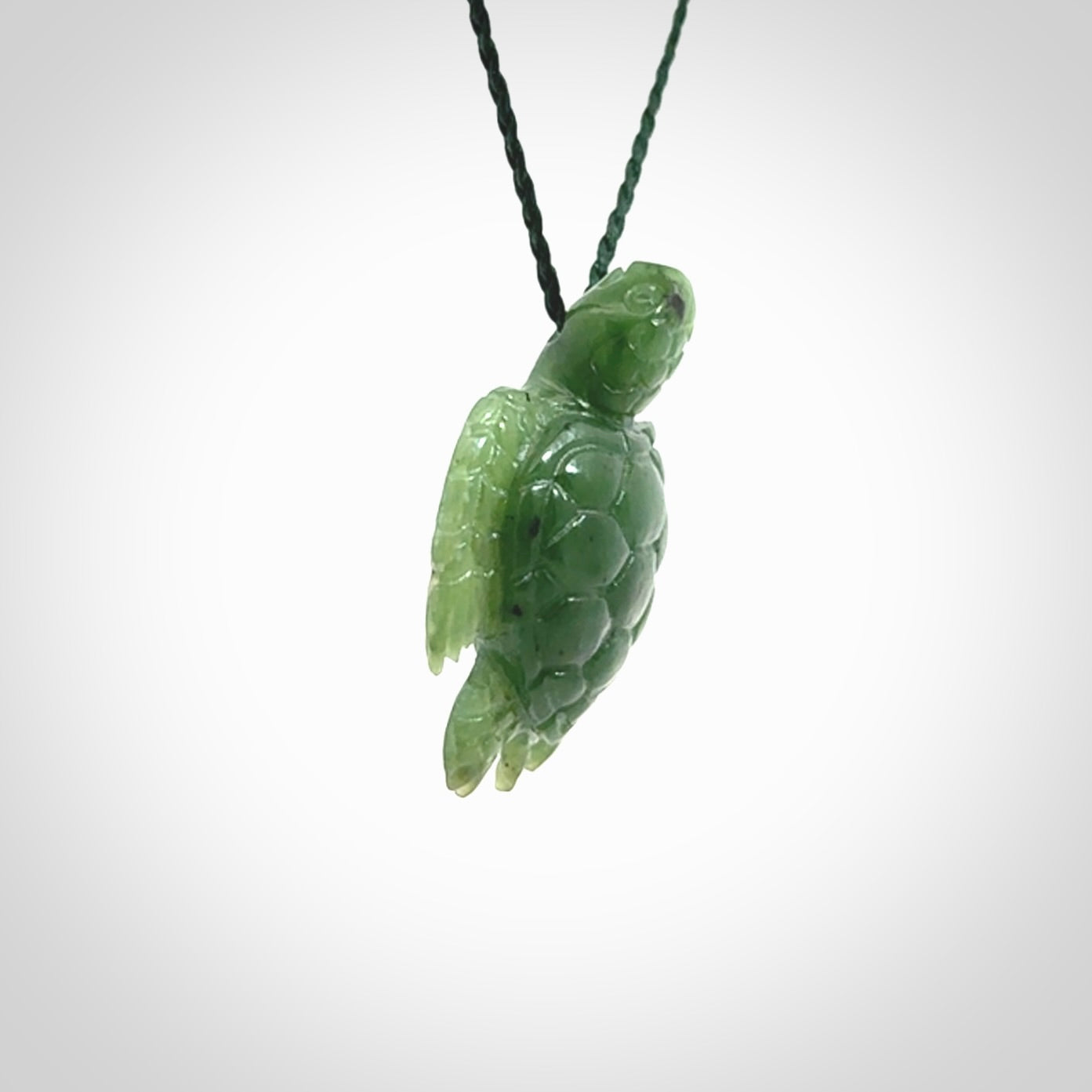 British Columbian jade turtle pendant. Hand carved jade turtle pendant, made by NZ Pacific for sale online. Unique handmade jewellery. Provided with an adjustable cord and packaged in a woven kete pouch.