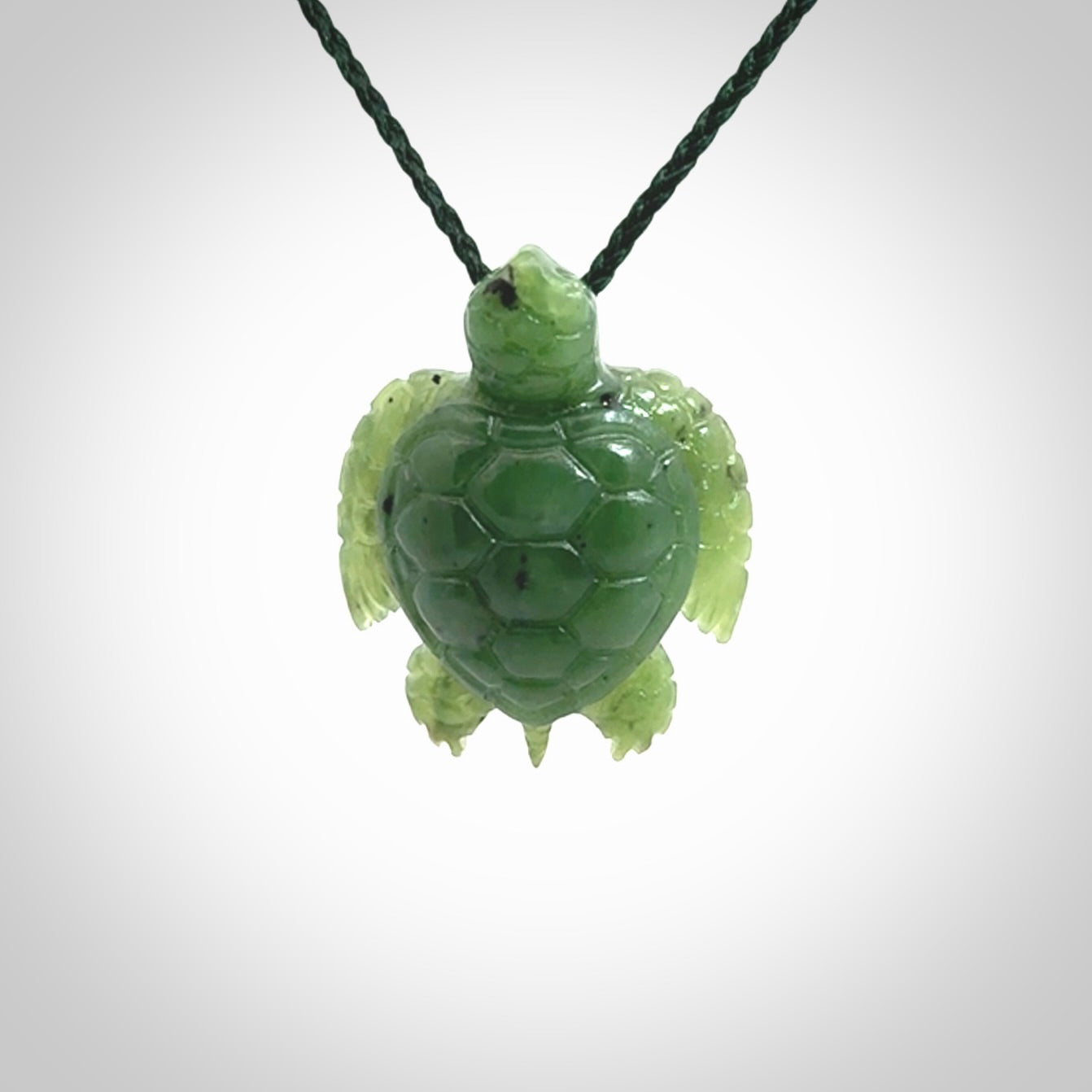 British Columbian jade turtle pendant. Hand carved jade turtle pendant, made by NZ Pacific for sale online. Unique handmade jewellery. Provided with an adjustable cord and packaged in a woven kete pouch.