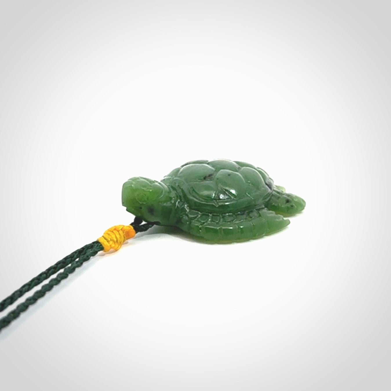 British Columbian jade turtle pendant. Hand carved jade turtle pendant, made by NZ Pacific for sale online. Unique handmade jewellery. Provided with an adjustable cord and packaged in a woven kete pouch.