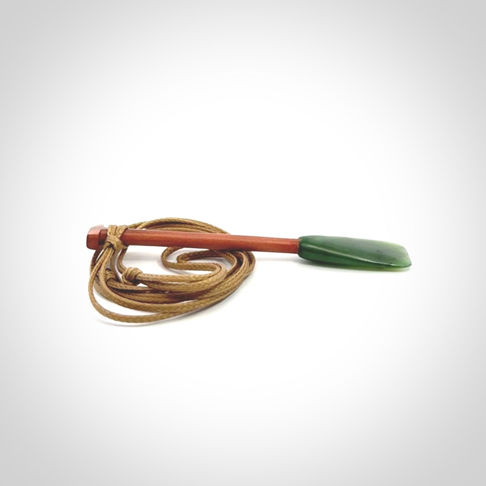 This pendant is a hand carved dragon boat paddle. We have carved this with a Green Nephrite jade blade and a hardwood handle. It is a necklace that was carved for suffered of breast cancer who are members of the Pink Dragons, a group or cancer fighters who take part in Dragon Boat racing events around the world.