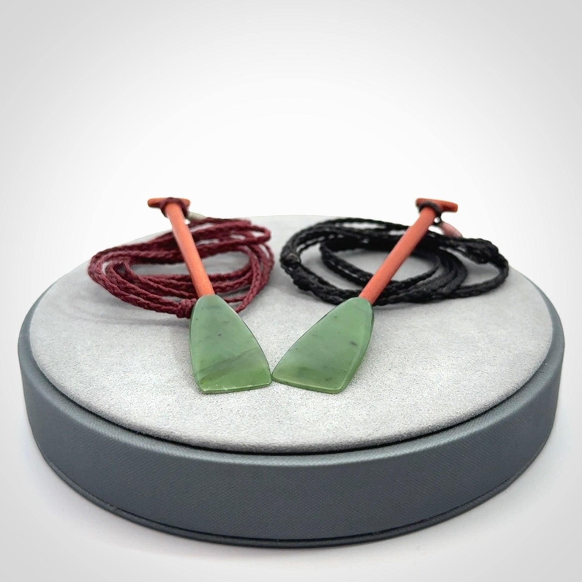 This pendant is a hand carved dragon boat paddle. We have carved this with a Green Nephrite jade blade and a hardwood handle. It is a necklace that was carved for suffered of breast cancer who are members of the Pink Dragons, a group or cancer fighters who take part in Dragon Boat racing events around the world.