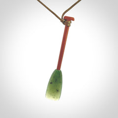 This pendant is a hand carved dragon boat paddle. We have carved this with a Green Nephrite jade blade and a hardwood handle. It is a necklace that was carved for suffered of breast cancer who are members of the Pink Dragons, a group or cancer fighters who take part in Dragon Boat racing events around the world.