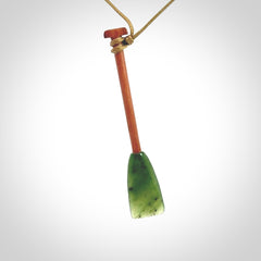 This pendant is a hand carved dragon boat paddle. We have carved this with a Green Nephrite jade blade and a hardwood handle. It is a necklace that was carved for suffered of breast cancer who are members of the Pink Dragons, a group or cancer fighters who take part in Dragon Boat racing events around the world.