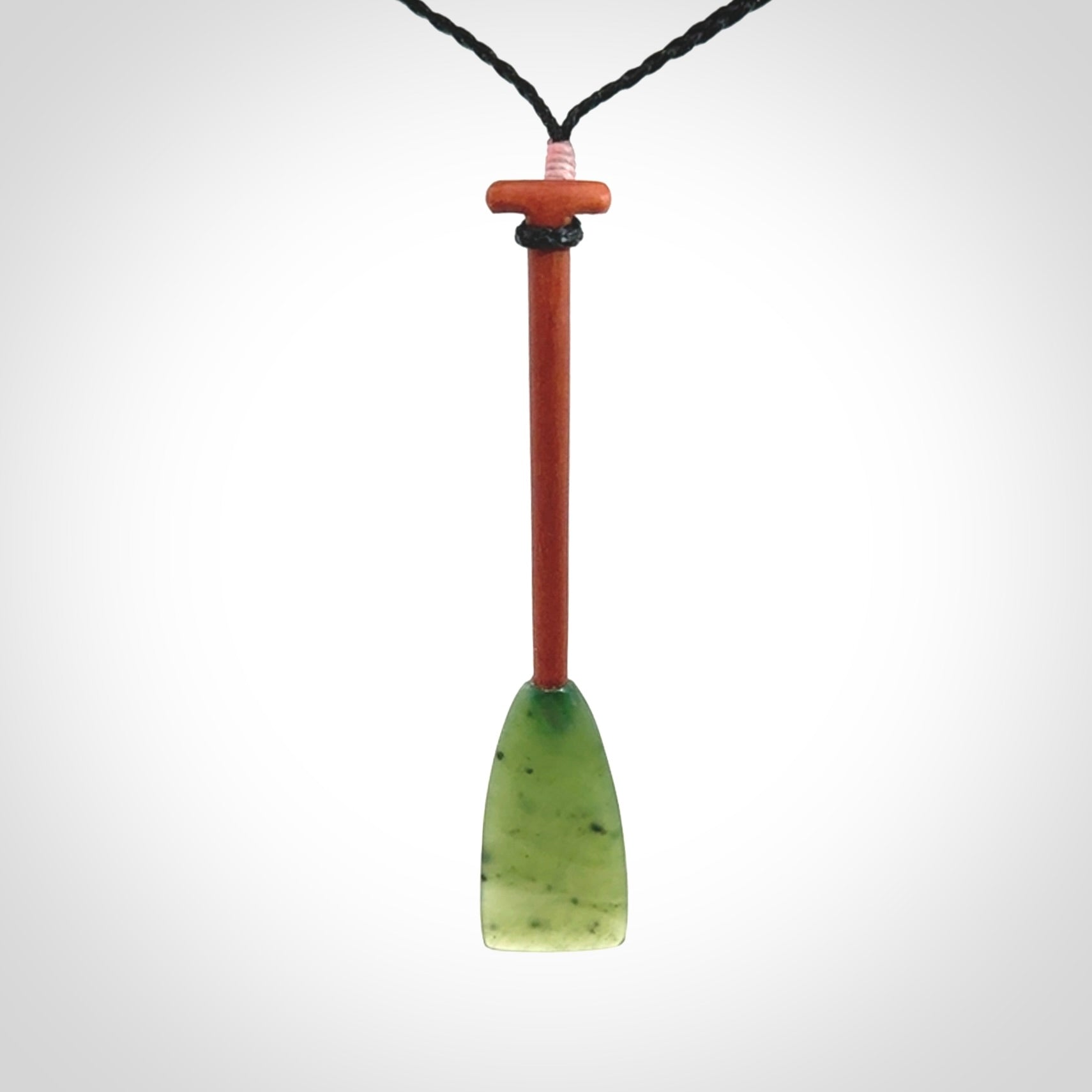 This pendant is a hand carved dragon boat paddle. We have carved this with a Green Nephrite jade blade and a hardwood handle. It is a necklace that was carved for suffered of breast cancer who are members of the Pink Dragons, a group or cancer fighters who take part in Dragon Boat racing events around the world.