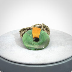 This is a hand carved disc pendant. Graeme carved this from Nephrite Jade. It is a gorgeous green colour and is an artistic piece of jewellery. Hand made by Graeme Wylie and delivered to you in a kete pouch.