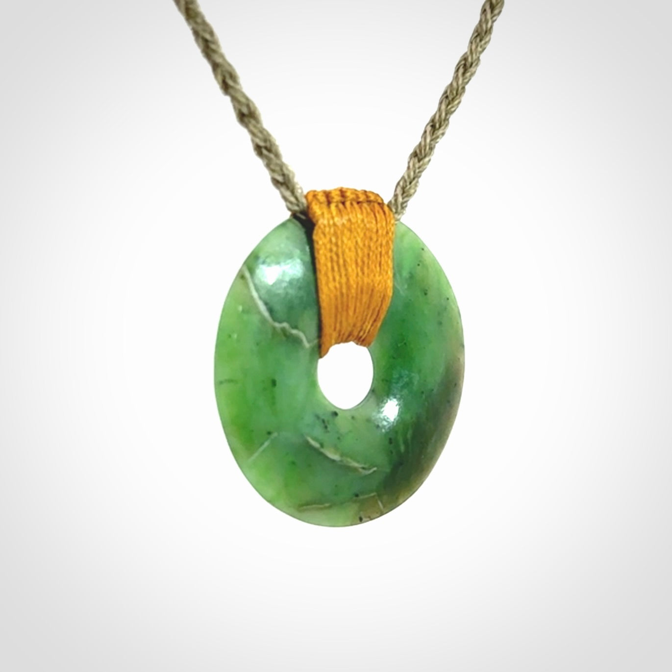This is a hand carved disc pendant. Graeme carved this from Nephrite Jade. It is a gorgeous green colour and is an artistic piece of jewellery. Hand made by Graeme Wylie and delivered to you in a kete pouch.