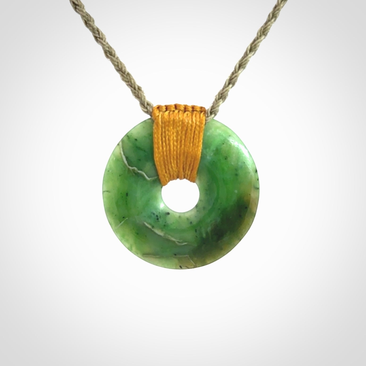 This is a hand carved disc pendant. Graeme carved this from Nephrite Jade. It is a gorgeous green colour and is an artistic piece of jewellery. Hand made by Graeme Wylie and delivered to you in a kete pouch.