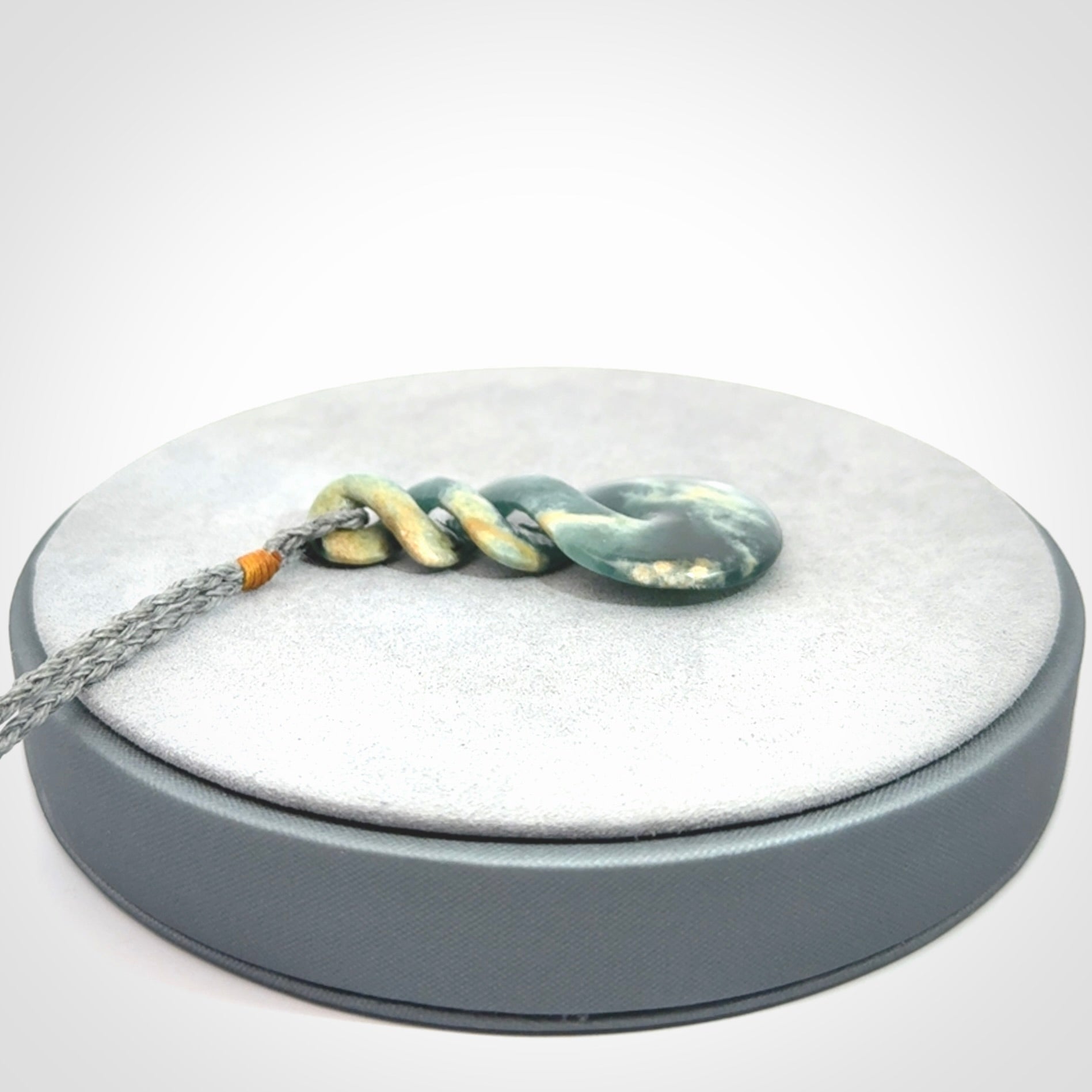 This is a hand carved triple twist pendant. Graeme carved this from Guatemalan Jadeite. It is a gorgeous blue colour and is an artistic piece of jewellery. Hand made by Graeme Wylie and delivered to you in a kete pouch.