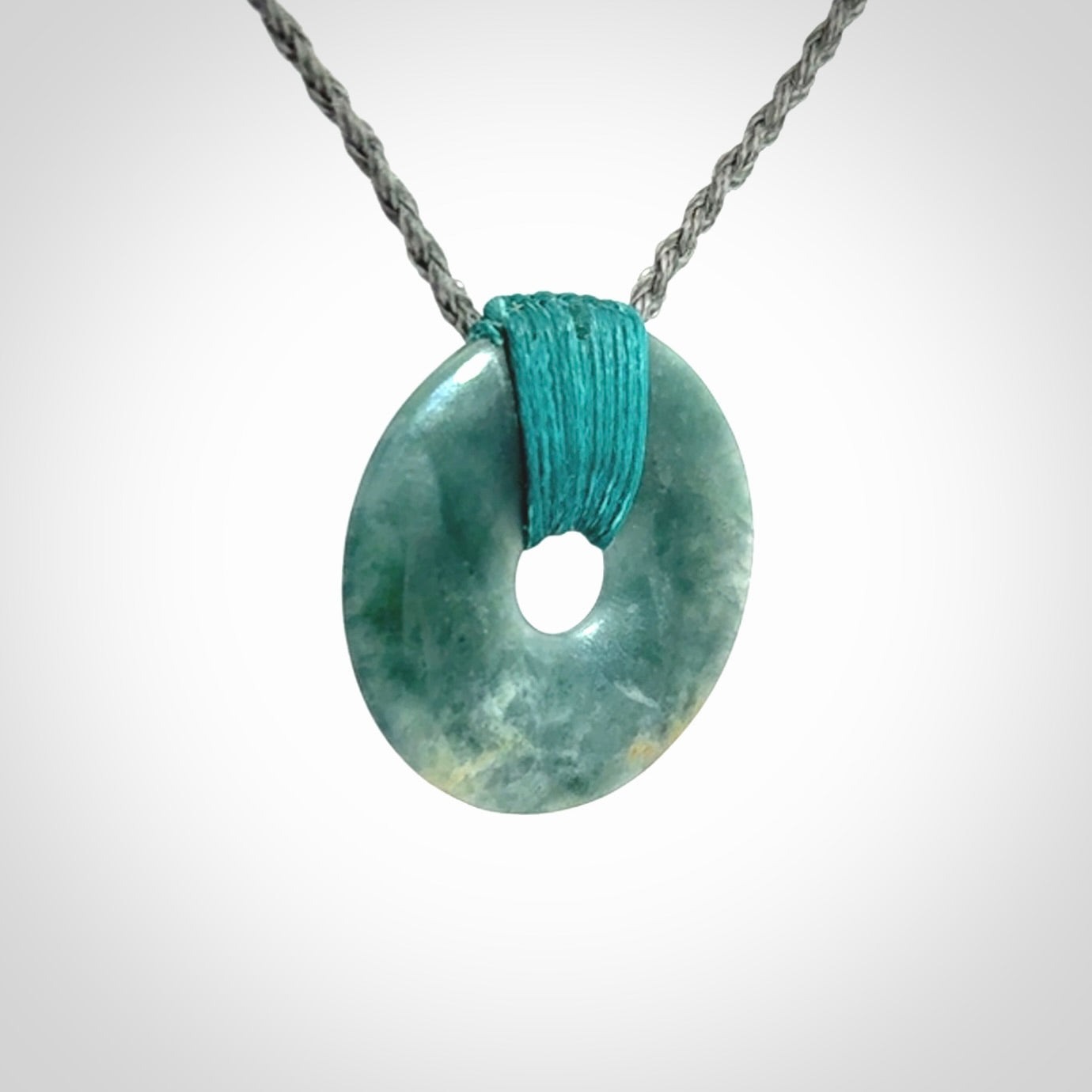This is a hand carved disc pendant. Graeme carved this from Guatemalan Jadeite. It is a gorgeous blue colour and is an artistic piece of jewellery. Hand made by Graeme Wylie and delivered to you in a kete pouch.