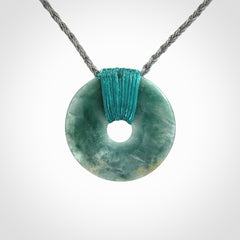 This is a hand carved disc pendant. Graeme carved this from Guatemalan Jadeite. It is a gorgeous blue colour and is an artistic piece of jewellery. Hand made by Graeme Wylie and delivered to you in a kete pouch.