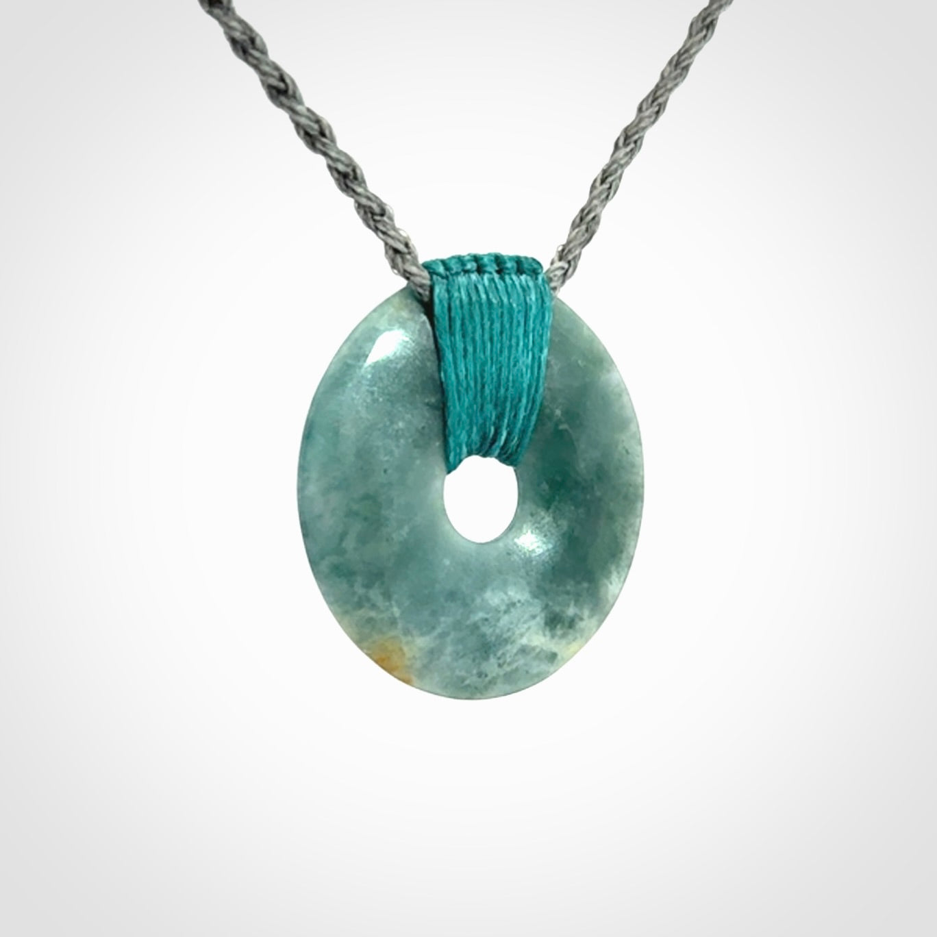 This is a hand carved disc pendant. Graeme carved this from Guatemalan Jadeite. It is a gorgeous blue colour and is an artistic piece of jewellery. Hand made by Graeme Wylie and delivered to you in a kete pouch.