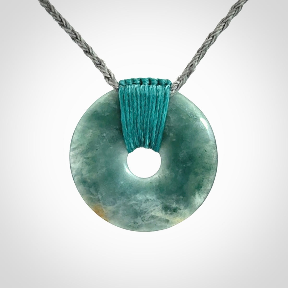 This is a hand carved disc pendant. Graeme carved this from Guatemalan Jadeite. It is a gorgeous blue colour and is an artistic piece of jewellery. Hand made by Graeme Wylie and delivered to you in a kete pouch.