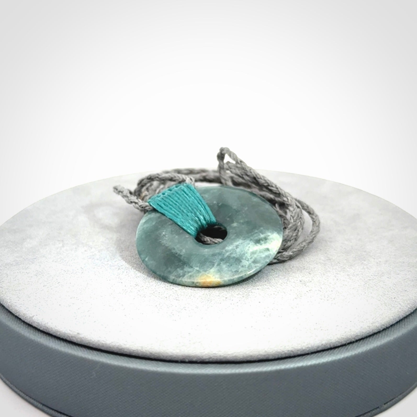 This is a hand carved disc pendant. Graeme carved this from Guatemalan Jadeite. It is a gorgeous blue colour and is an artistic piece of jewellery. Hand made by Graeme Wylie and delivered to you in a kete pouch.