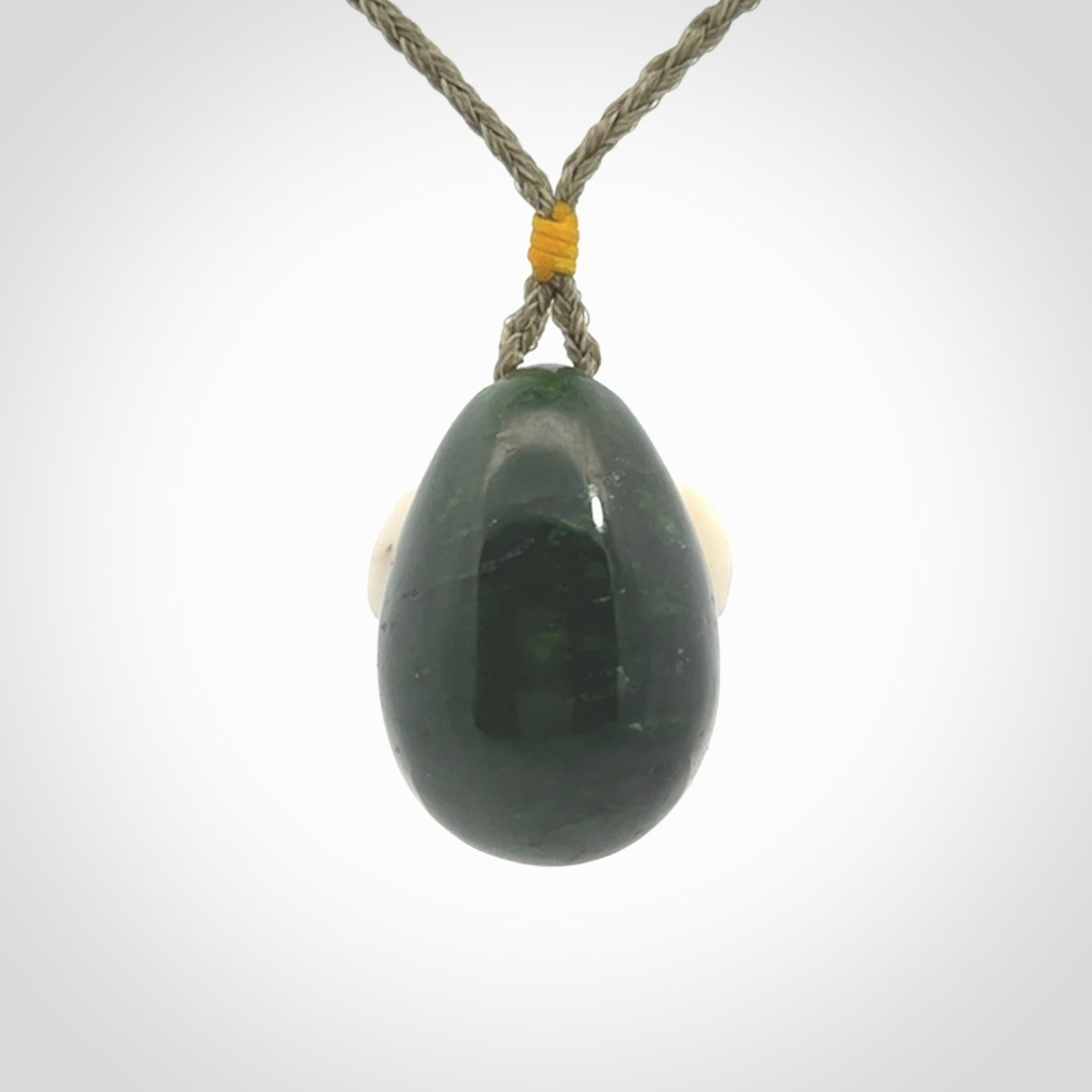 Hand carved turtle hatchling pendant. The egg is carved from green British Columbian jade and the turtle from bone. Designed and carved by NZ Pacific and for sale online.