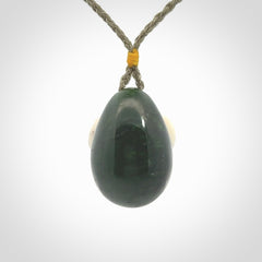 Hand carved turtle hatchling pendant. The egg is carved from green British Columbian jade and the turtle from bone. Designed and carved by NZ Pacific and for sale online.