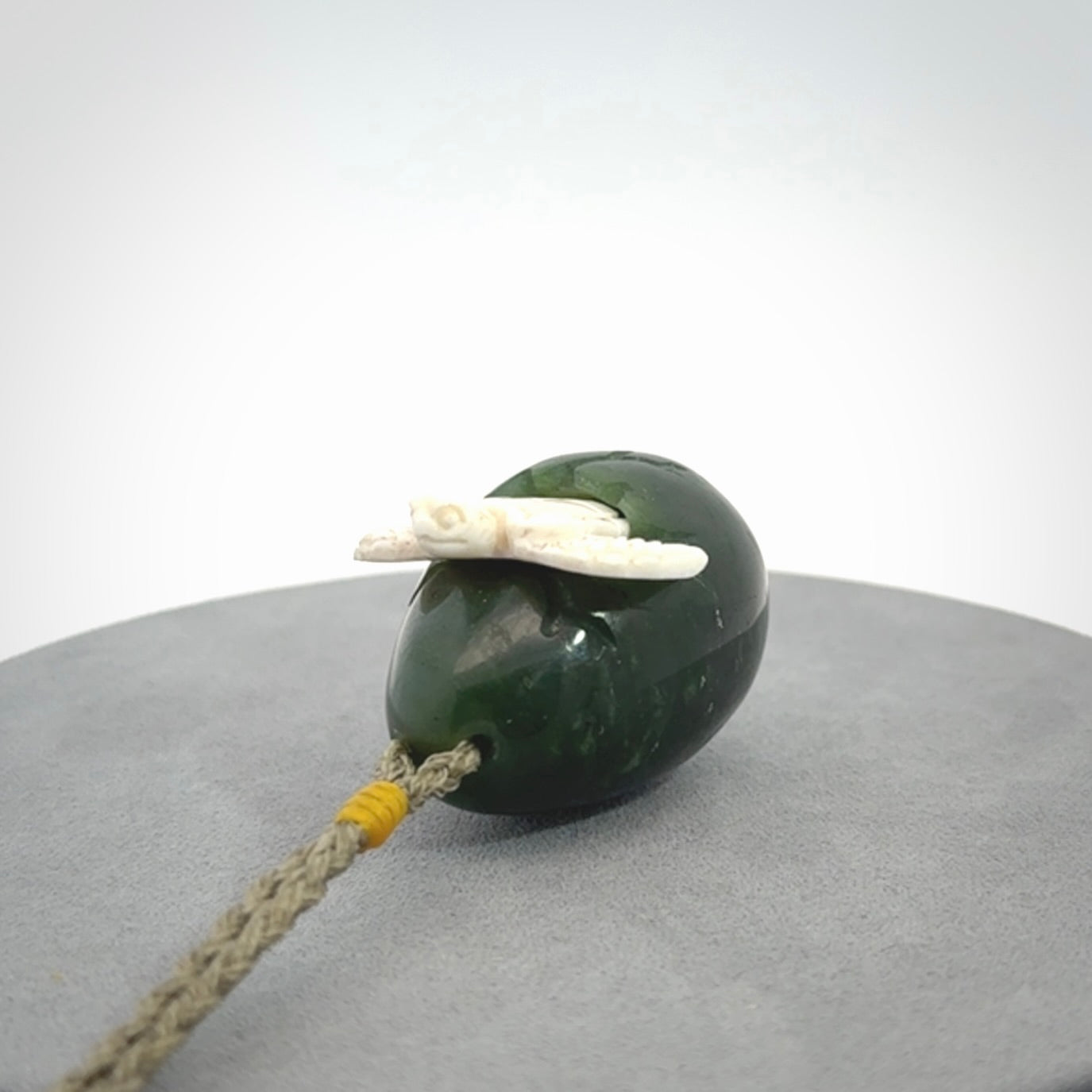 Hand carved turtle hatchling pendant. The egg is carved from green British Columbian jade and the turtle from bone. Designed and carved by NZ Pacific and for sale online.