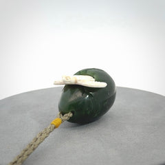 Hand carved turtle hatchling pendant. The egg is carved from green British Columbian jade and the turtle from bone. Designed and carved by NZ Pacific and for sale online.