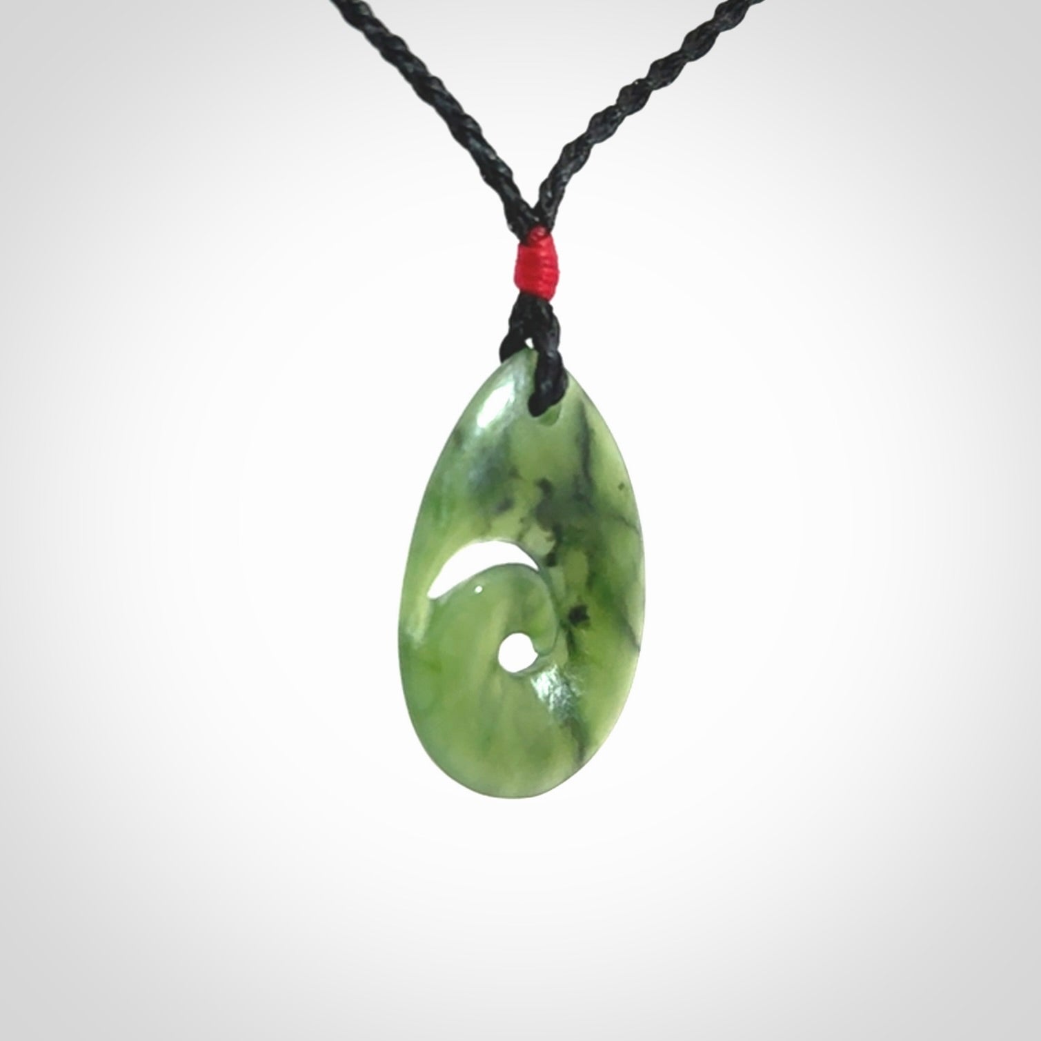 Hand carved New Zealand jade koru drop pendant. Made by NZ Pacific.Hand carved New Zealand jade koru drop pendant. Made by NZ Pacific.