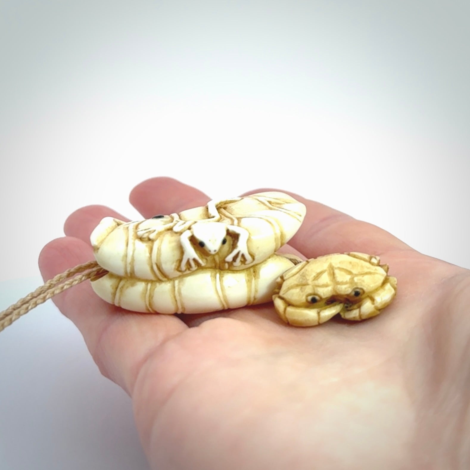 Hand carved bone frog on lotus leaf with moving crab pendant. Made from Bone in New Zealand. Made by master bone carver Fumio Noguchi. Spectacular collectable work of art, made to wear. One only pendant, delivered to you with express courier on a beige adjustable cord.