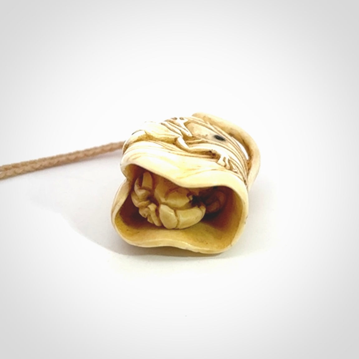 Hand carved bone frog on lotus leaf with moving crab pendant. Made from Bone in New Zealand. Made by master bone carver Fumio Noguchi. Spectacular collectable work of art, made to wear. One only pendant, delivered to you with express courier on a beige adjustable cord.