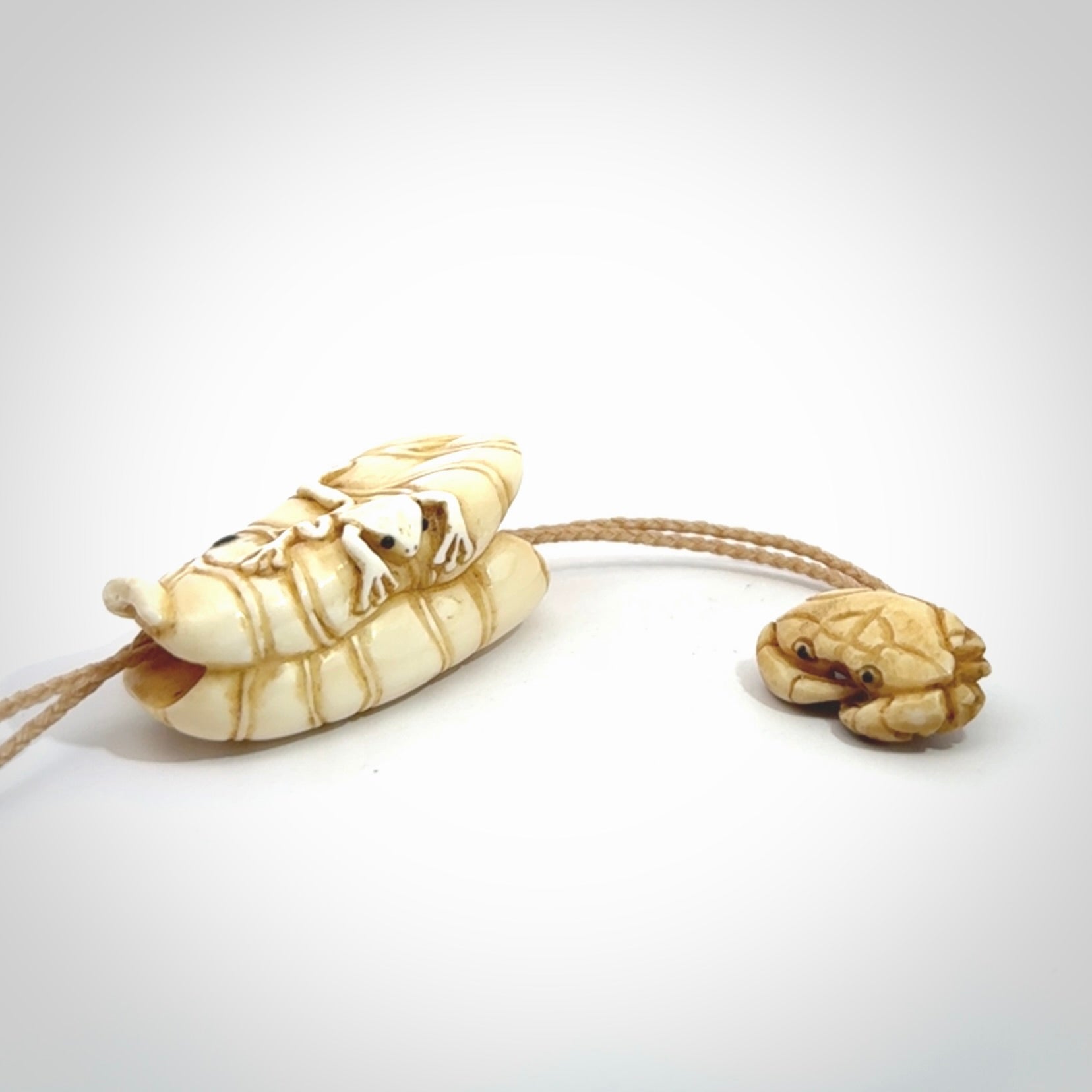 Hand carved bone frog on lotus leaf with moving crab pendant. Made from Bone in New Zealand. Made by master bone carver Fumio Noguchi. Spectacular collectable work of art, made to wear. One only pendant, delivered to you with express courier on a beige adjustable cord.