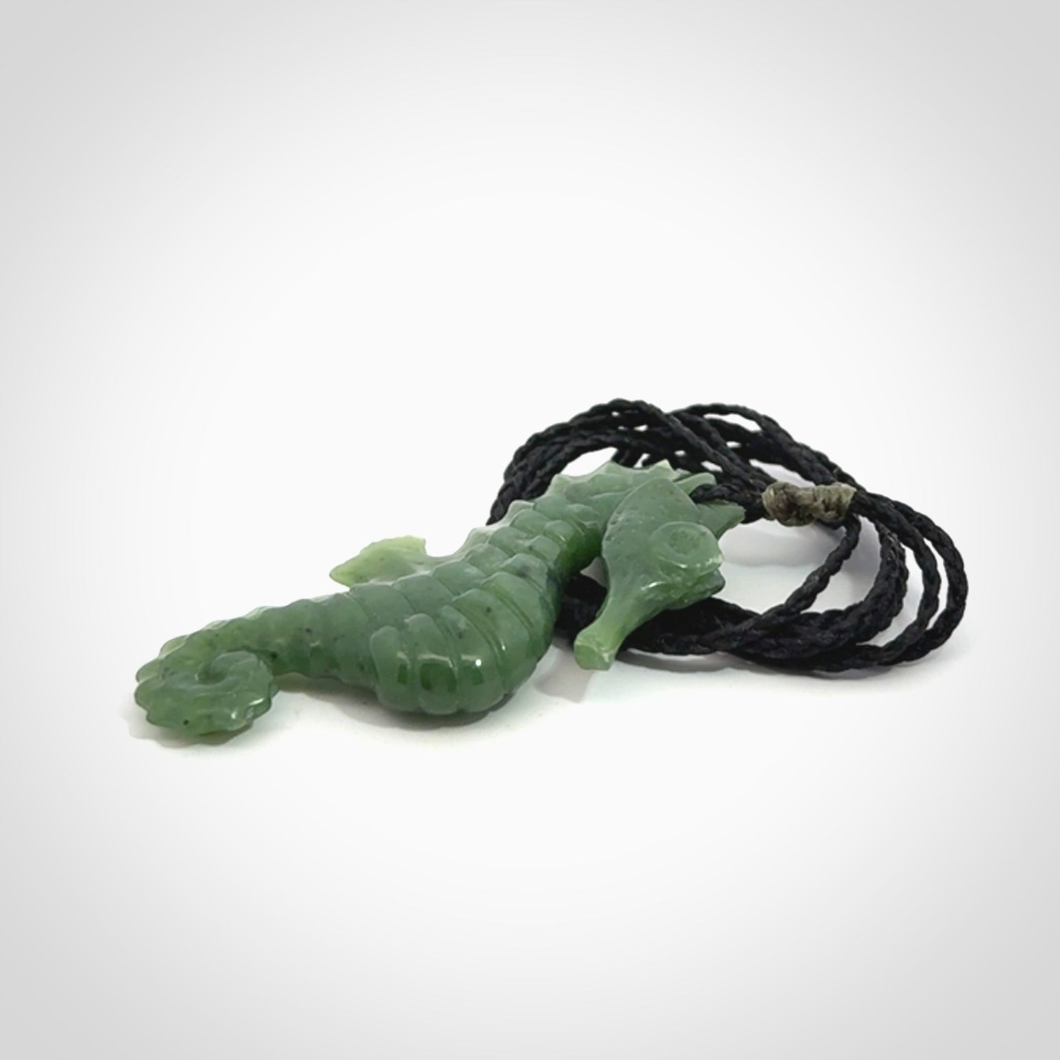 A hand carved seahorse pendant. We have carved this from beautiful nephrite jade and we bind them with our hand-plaited cords. We ship these worldwide with express courier anywhere in the world.