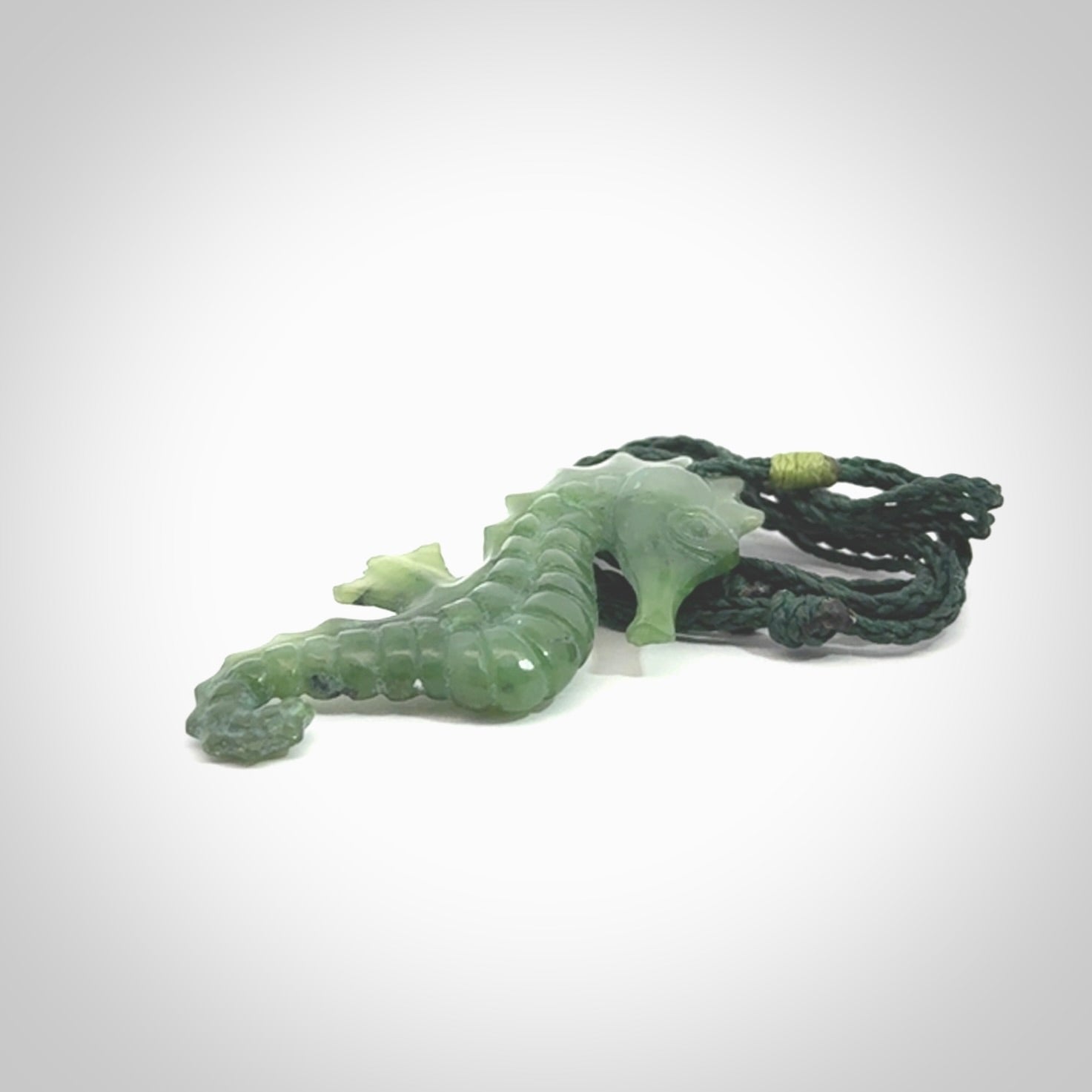 A hand carved seahorse pendant. We have carved this from beautiful nephrite jade and we bind them with our hand-plaited cords. We ship these worldwide with express courier anywhere in the world.