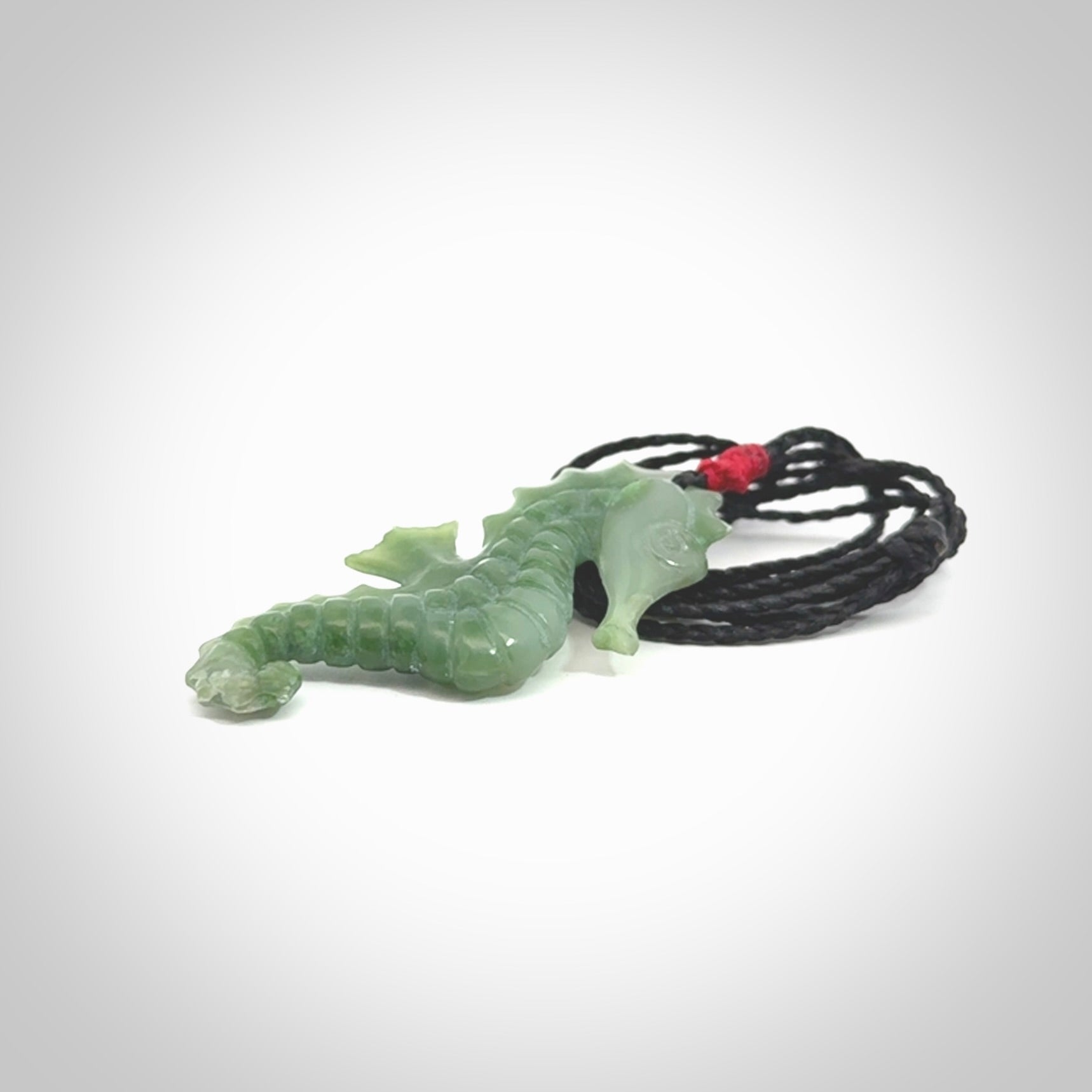 A hand carved seahorse pendant. We have carved this from beautiful nephrite jade and we bind them with our hand-plaited cords. We ship these worldwide with express courier anywhere in the world.