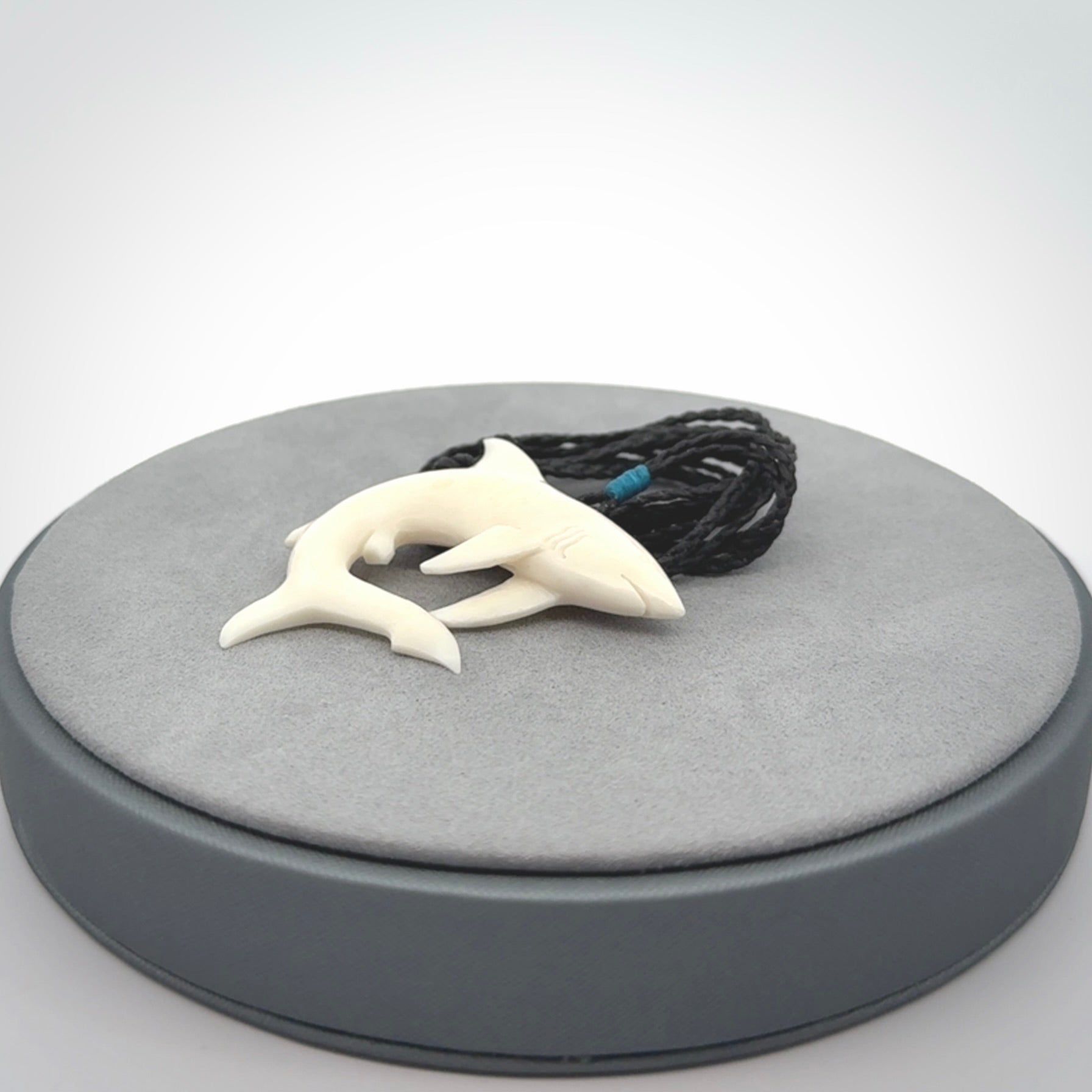 This photo shows a bone shark pendant hand carved in bone. It is provided with an adjustable cord.