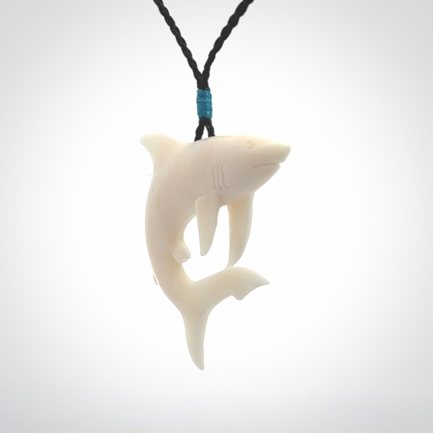 This photo shows a bone shark pendant hand carved in bone. It is provided with an adjustable cord.