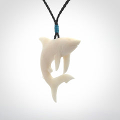 This photo shows a bone shark pendant hand carved in bone. It is provided with an adjustable cord.