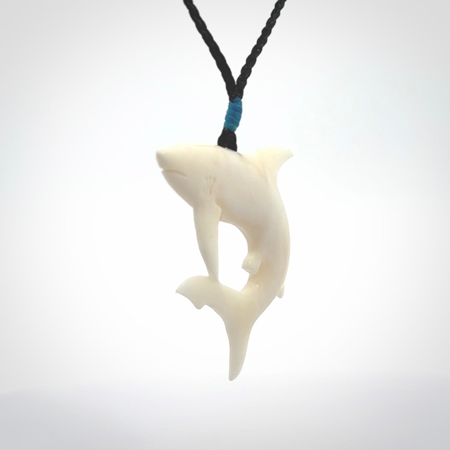 This photo shows a bone shark pendant hand carved in bone. It is provided with an adjustable cord.