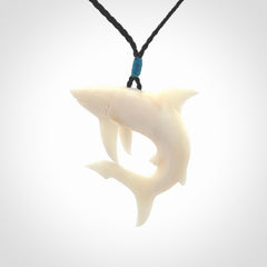 This photo shows a bone shark pendant hand carved in bone. It is provided with an adjustable cord.