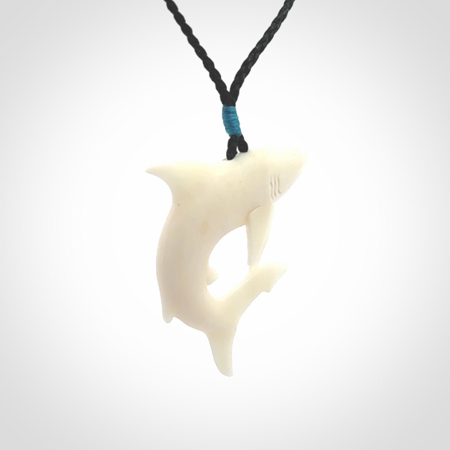 This photo shows a bone shark pendant hand carved in bone. It is provided with an adjustable cord.