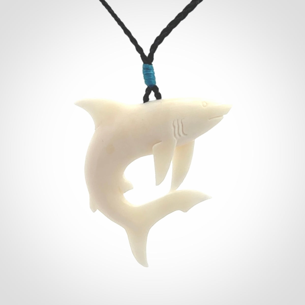 This photo shows a bone shark pendant hand carved in bone. It is provided with an adjustable cord.