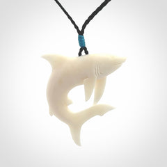 This photo shows a bone shark pendant hand carved in bone. It is provided with an adjustable cord.
