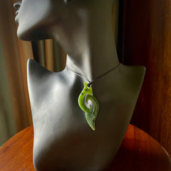 This photo shows a contemporary koru pendant carved from New Zealand Jade. The artist, Shaun Gardiner, has carved this beautifully. We provide this piece with an adjustable black cord. This is a fantastic work of art, we have one only.