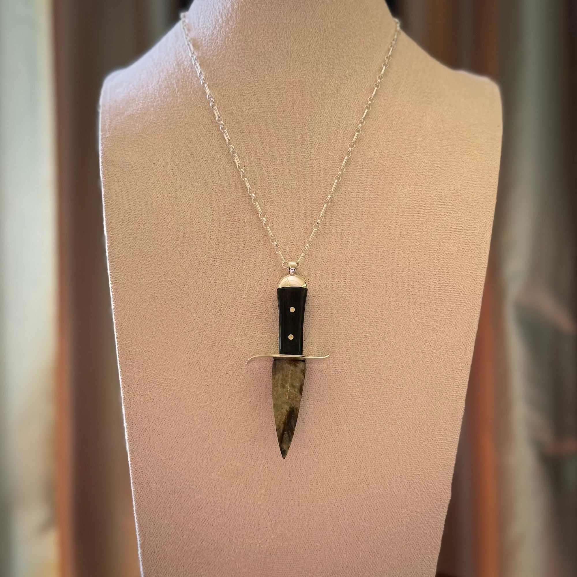 A striking hand carved knife pendant. These are carved with a green jade head and a hardwood handle. The necklace is sterling silver. We ship these worldwide with express courier.