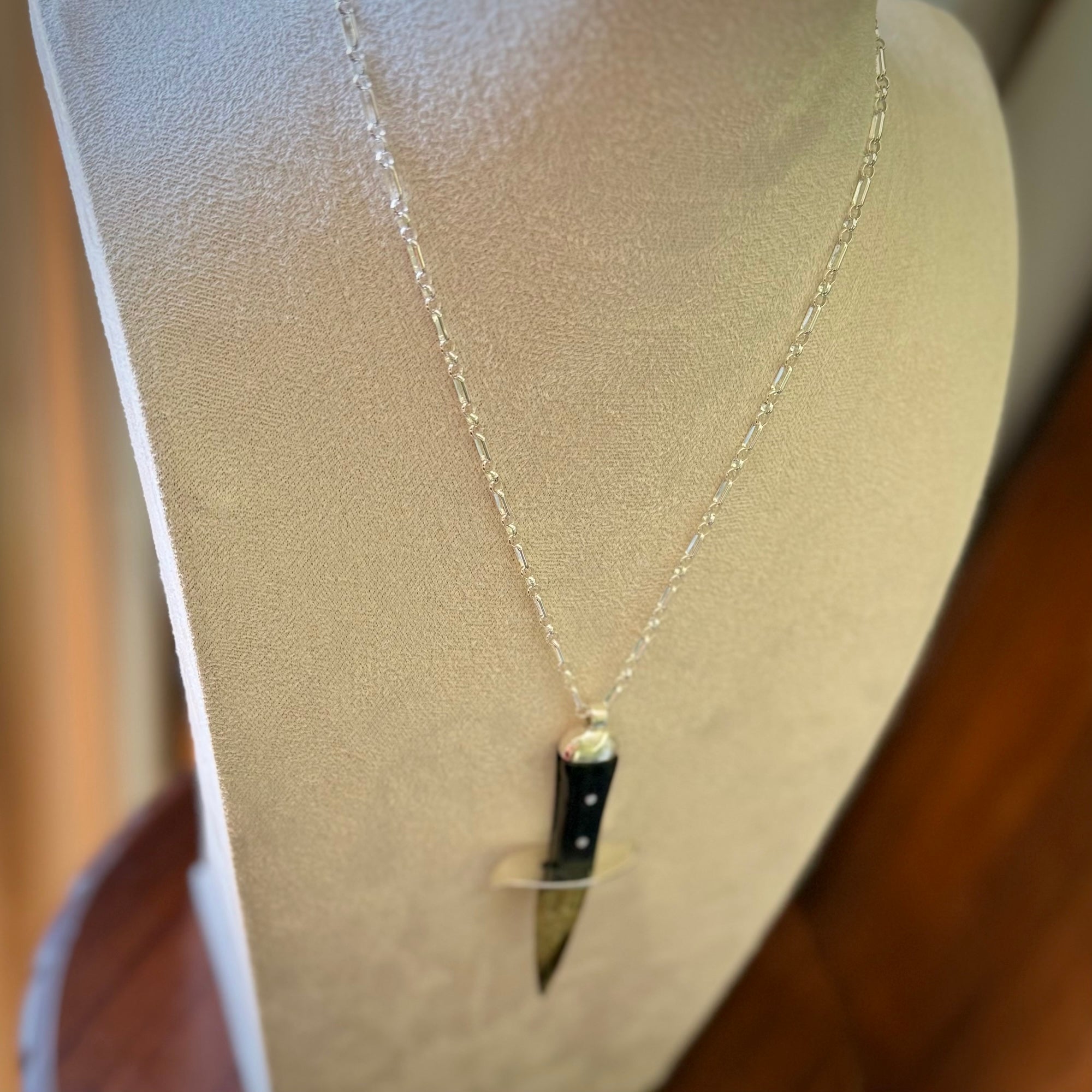 A striking hand carved knife pendant. These are carved with a green jade head and a hardwood handle. The necklace is sterling silver. We ship these worldwide with express courier.