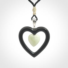 Black Jade Heart pendant with Jadeite heart centre. Hand carved for NZ Pacific. Handmade jewellery for sale online. The cord is a 3-braid plait in black and is adjustable. Double heart necklace for men and women. Heart necklace hand made from black jade stone and Jadeite.