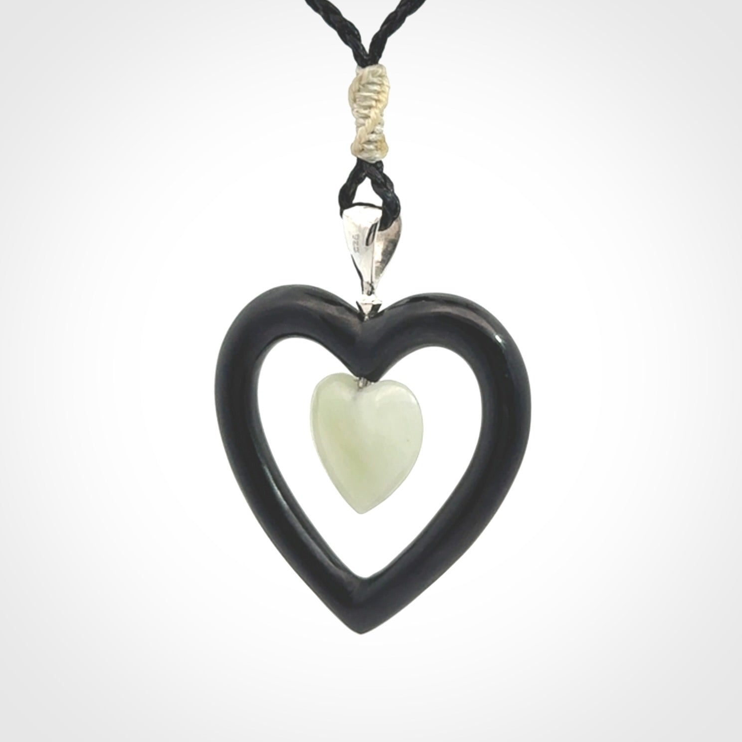 Black Jade Heart pendant with Jadeite heart centre. Hand carved for NZ Pacific. Handmade jewellery for sale online. The cord is a 3-braid plait in black and is adjustable. Double heart necklace for men and women. Heart necklace hand made from black jade stone and Jadeite.