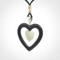 Black Jade Heart pendant with Jadeite heart centre. Hand carved for NZ Pacific. Handmade jewellery for sale online. The cord is a 3-braid plait in black and is adjustable. Double heart necklace for men and women. Heart necklace hand made from black jade stone and Jadeite.