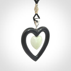 Black Jade Heart pendant with Jadeite heart centre. Hand carved for NZ Pacific. Handmade jewellery for sale online. The cord is a 3-braid plait in black and is adjustable. Double heart necklace for men and women. Heart necklace hand made from black jade stone and Jadeite.