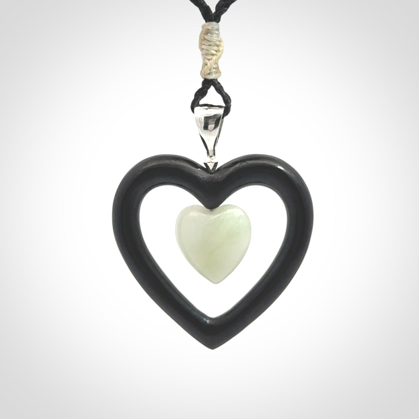 Black Jade Heart pendant with Jadeite heart centre. Hand carved for NZ Pacific. Handmade jewellery for sale online. The cord is a 3-braid plait in black and is adjustable. Double heart necklace for men and women. Heart necklace hand made from black jade stone and Jadeite.